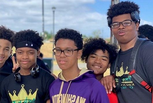 Five high school students pose for a photo together outside.